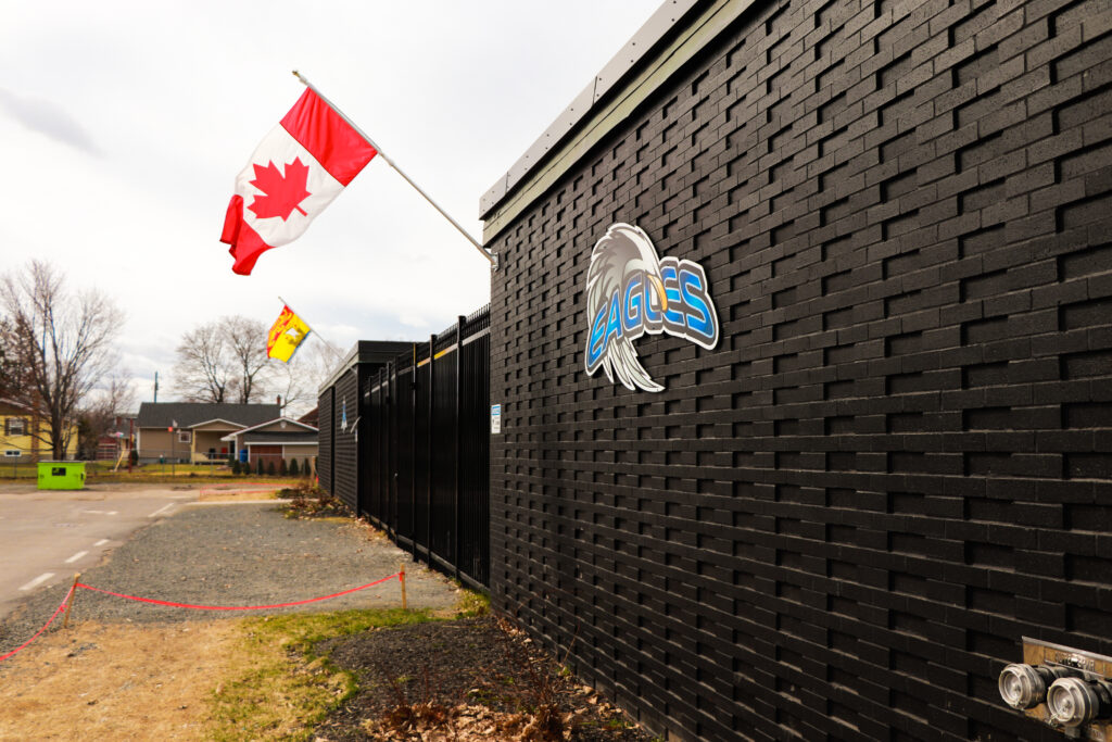 Fachada de Fredericton Christian Academy con las banderas de Canadá y de New Brunswick izadas.
