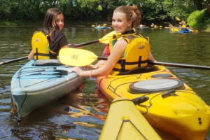 Alunas da Fredericton Christian Academy aproveitam passeio de caiaque durante o acampamento de verão.