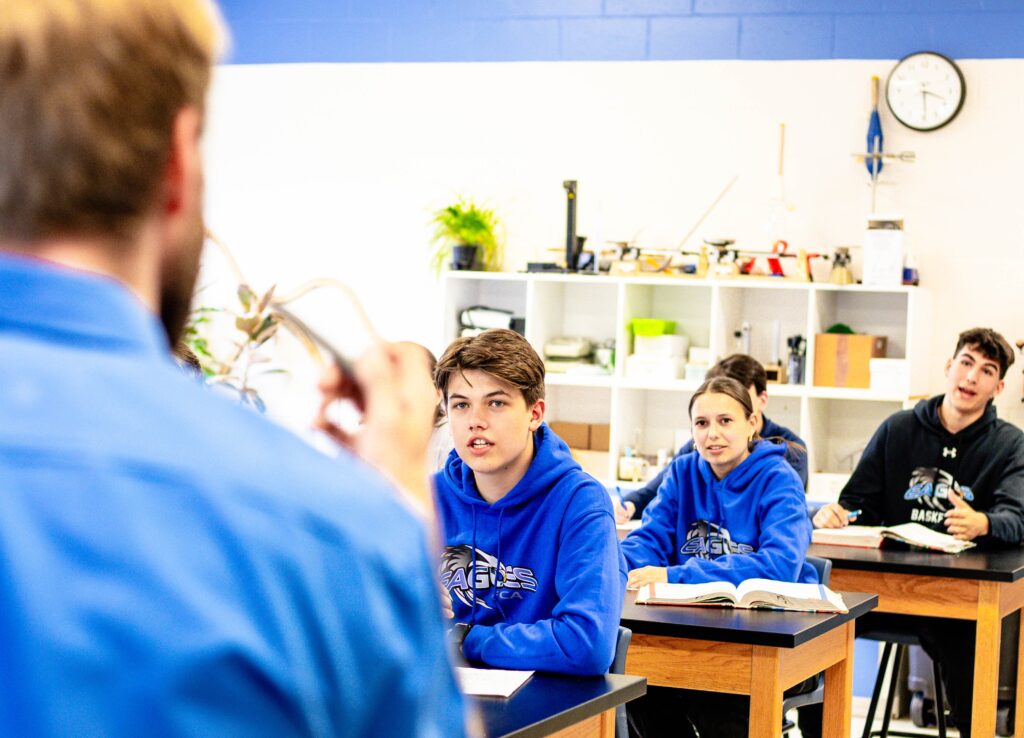 Students at Fredericton Christian Academy participating in a bilingual class with a teacher in a modern room.