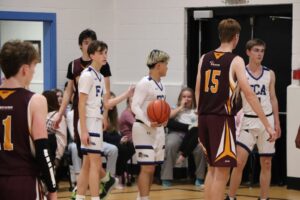 Alunos da Fredericton Christian Academy participando de jogo de basquetebol, promovendo esportes e trabalho em equipe.