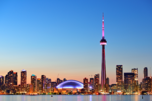 Vista noturna da skyline de Toronto com a CN Tower iluminada, um dos pontos turísticos mais icônicos do Canadá.