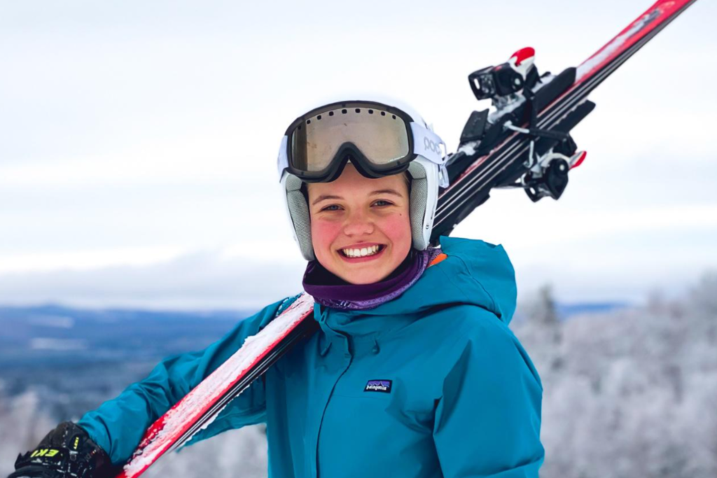 Estudante da Fredericton Christian Academy sorrindo com equipamento de esqui, praticando esportes de inverno.