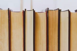 Conjunto de livros organizados verticalmente, simbolizando a busca pelo conhecimento acadêmico associada à plataforma UniversityNow.