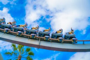 Pessoas se divertindo em uma montanha-russa no parque de diversões Canada's Wonderland, sob um céu azul com nuvens.