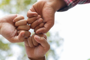 Três mãos se cumprimentando com soquinhos, representando o espírito de custodianship e colaboração.