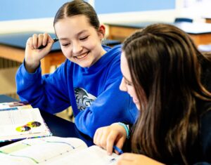 Alunas da Fredericton Christian Academy estudando juntas em sala de aula, representando o programa de estudos no Canadá.