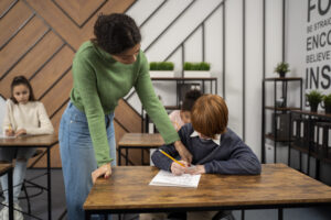 Professora orientando aluno durante atividade em sala de aula na Fredericton Christian Academy, representando a supervisão estudantil individualizada.