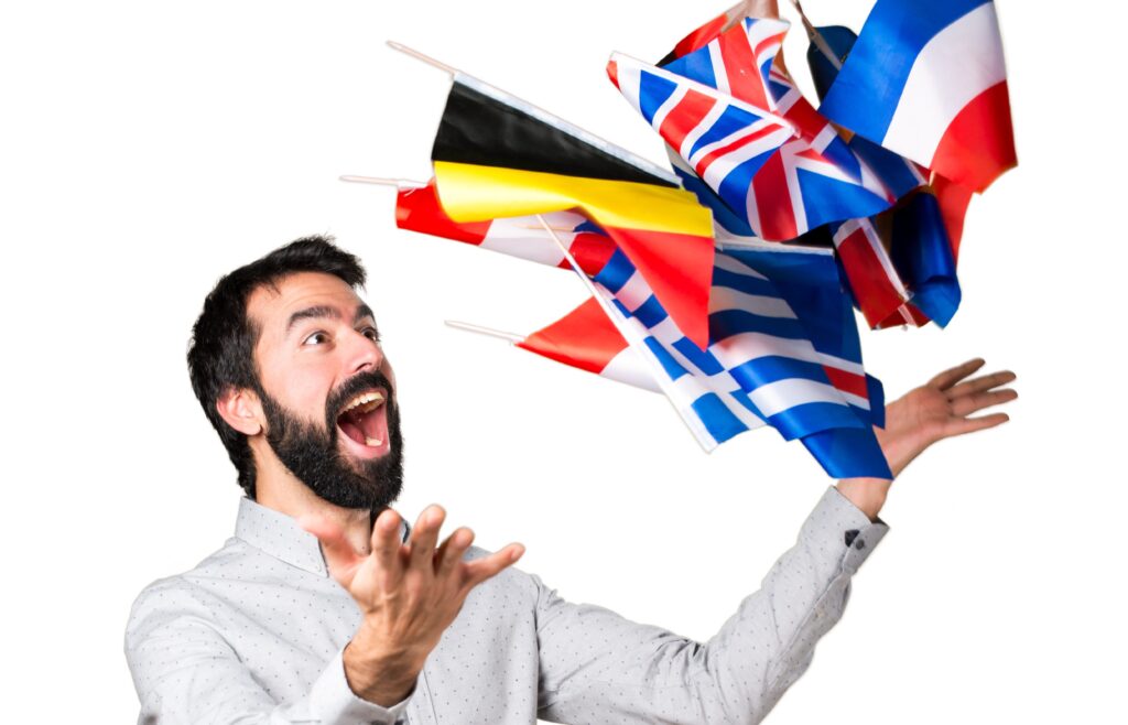 Persona que expresa alegría mientras lanza banderas de diferentes países, representando la educación bilingüe.