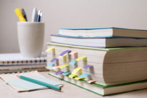 Livros com marcadores coloridos, caderno e lápis sobre a mesa de estudos