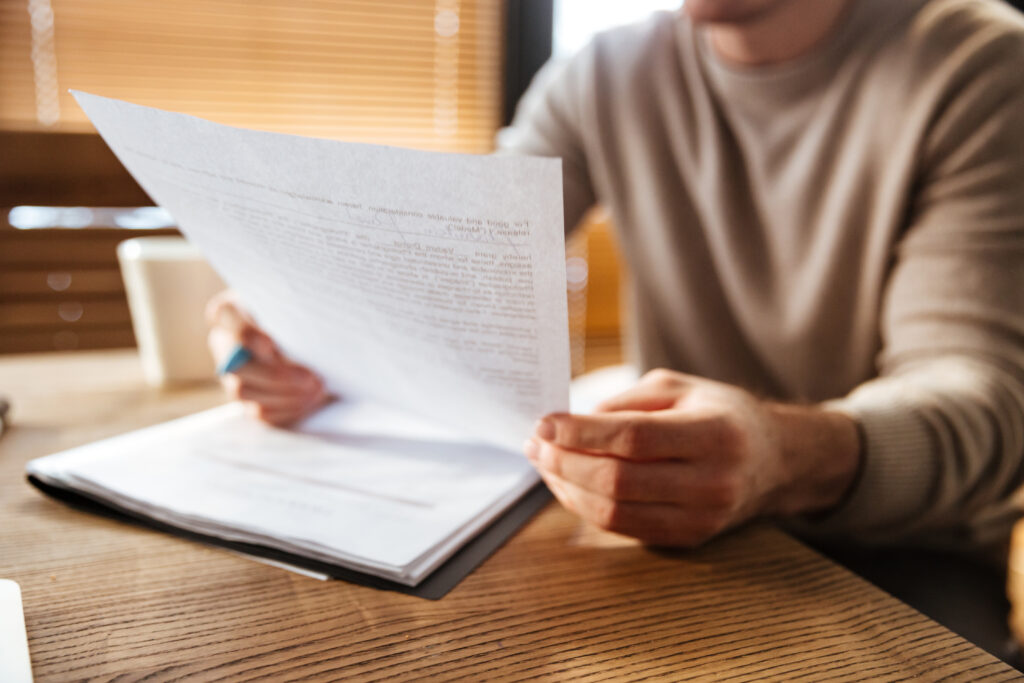 Persona con documento impreso que representa la carta de aceptación para estudios en Canadá