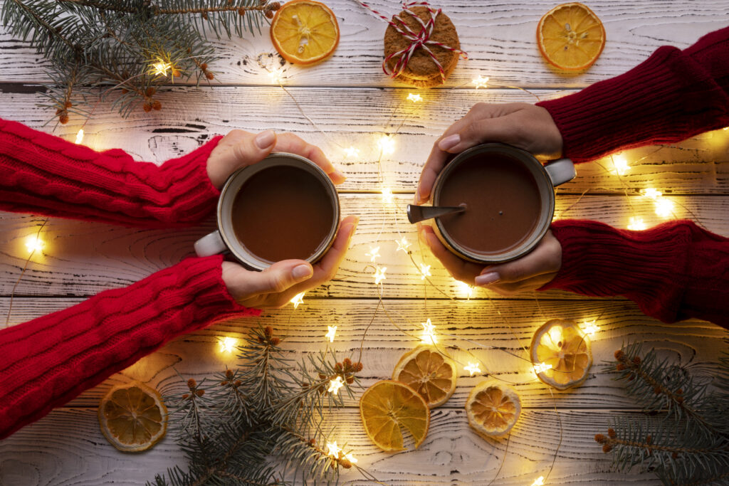 Duas pessoas brindando com chocolate quente durante as férias de Natal
