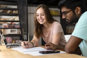 Dois estudantes estudando juntos e revisando informações acadêmicas