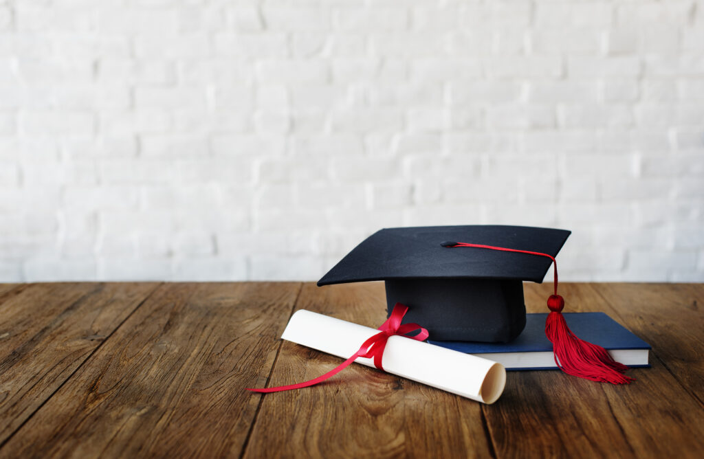 Cap and diploma on wooden table symbolizing graduation